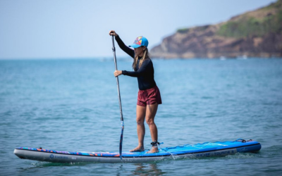 Person kayaking through clear blue waters during a basic water sports course adventure training session